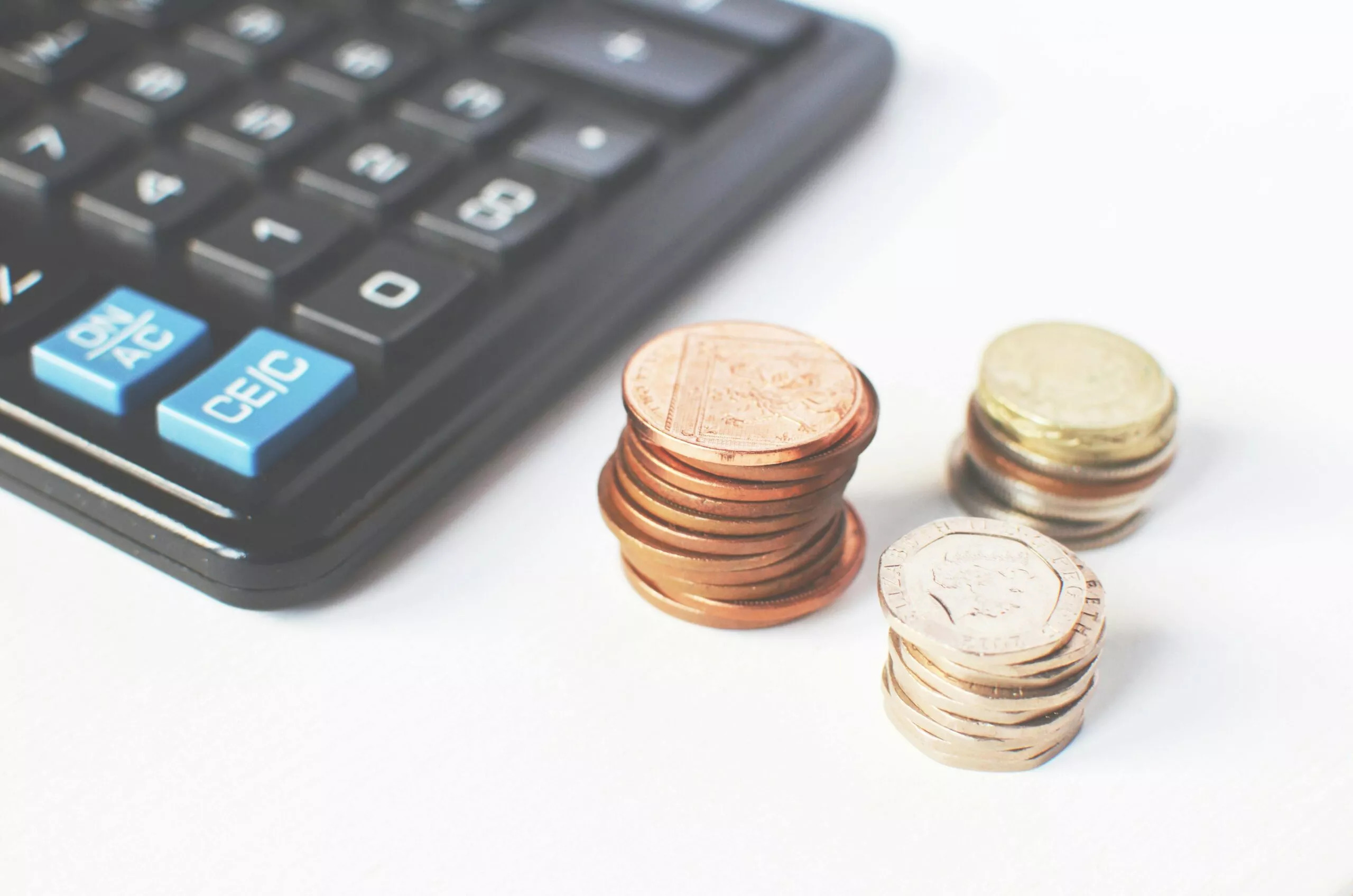 Image d'une calculatrice et de pièces de monnaies empilées